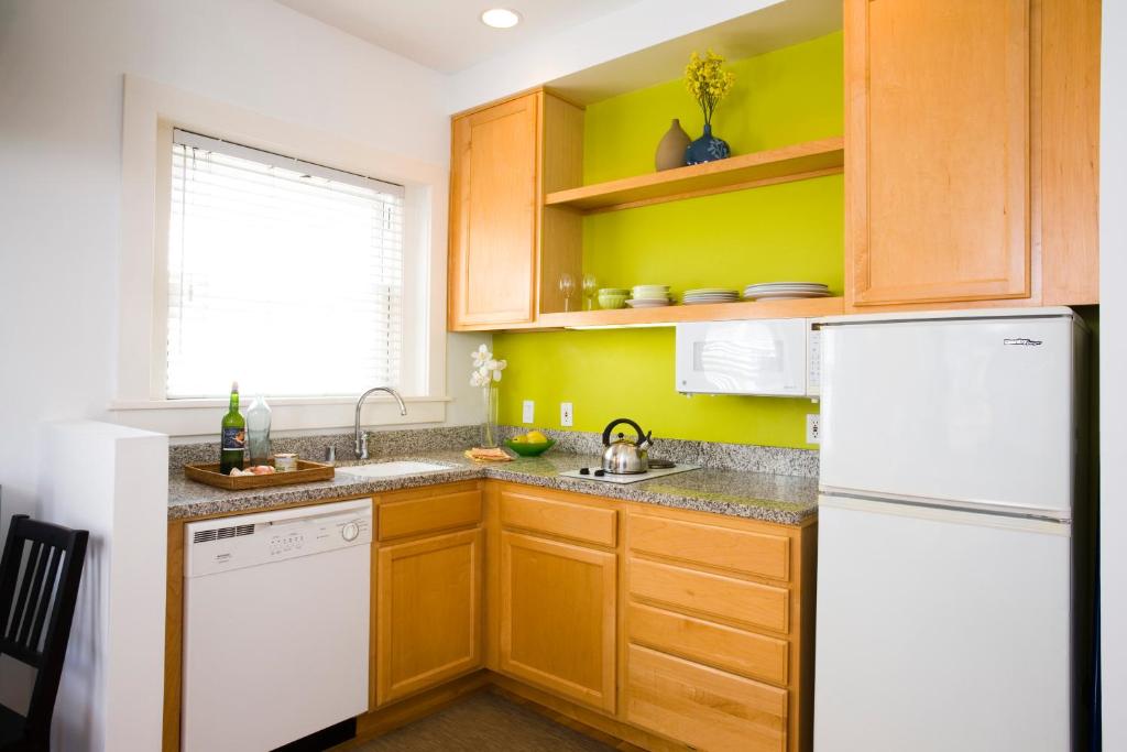 a kitchen with wooden cabinets and a white refrigerator at Venice Suites in Los Angeles