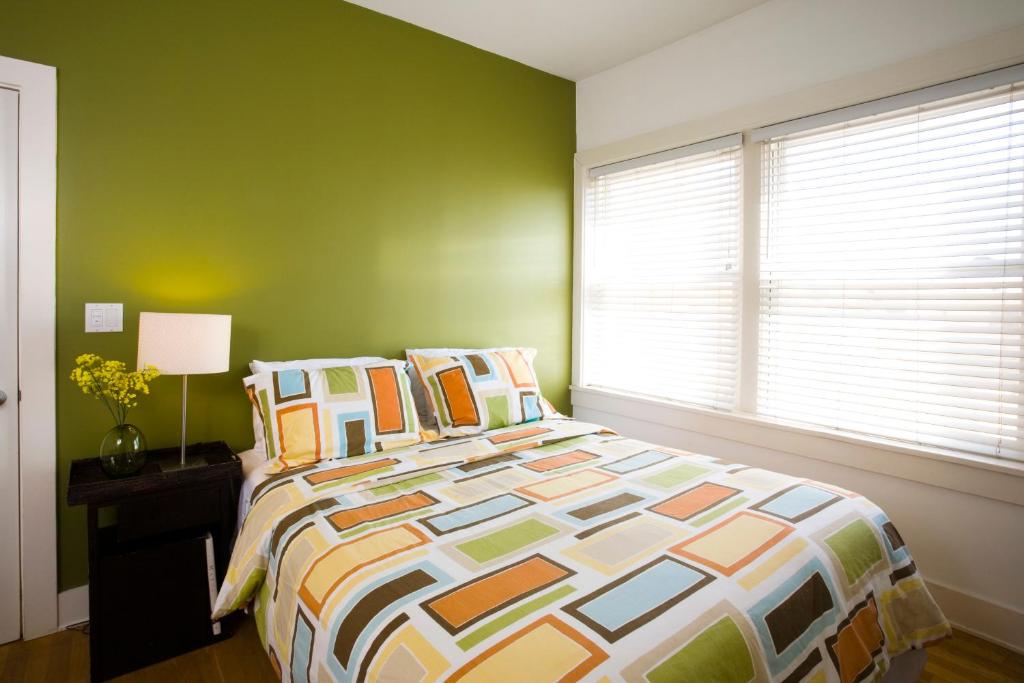 a bedroom with a bed and a green wall at Venice Suites in Los Angeles