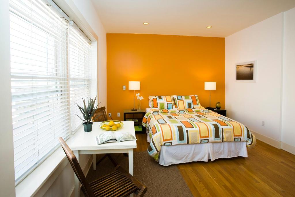 a bedroom with a bed and a table and a window at Venice Suites in Los Angeles