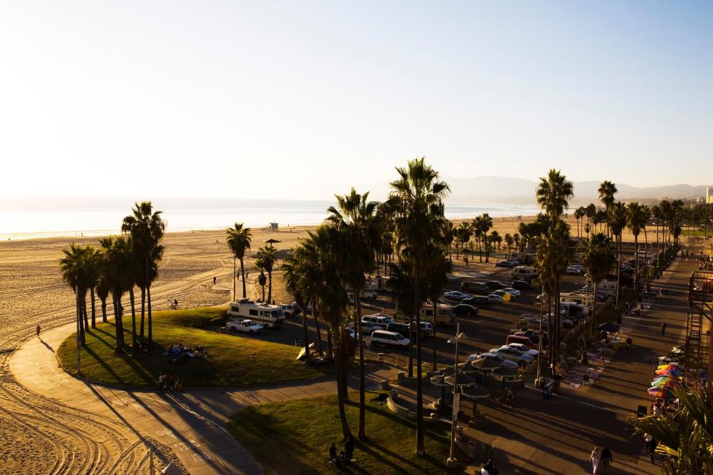 a parking lot with palm trees and a beach at Venice Suites in Los Angeles