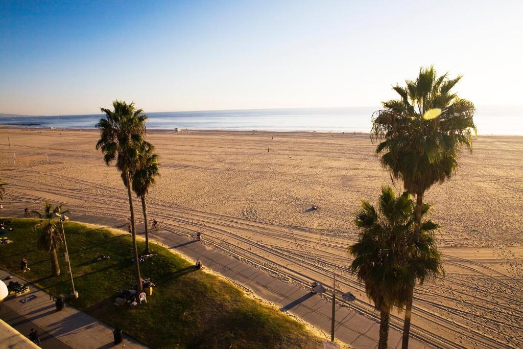 a view of a beach with palm trees and the ocean at Venice Suites in Los Angeles