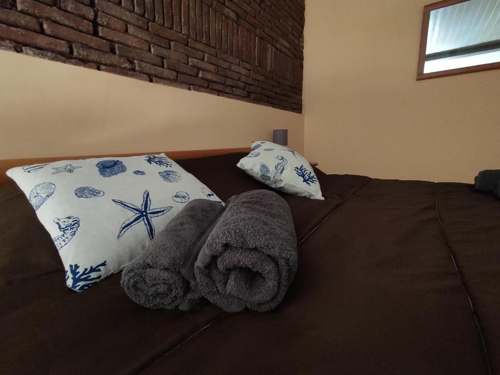 un letto con asciugamani e un cuscino sopra di Loft Casa Celeste a Catania