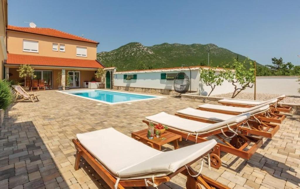 un patio con tumbonas y una piscina en Villa Zara with heated Hydromassage-Pool en Vrgorac