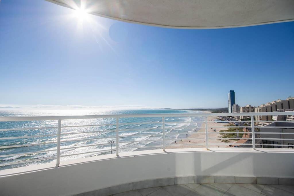a balcony with a view of the beach at Oceanfront Panoramic Beach View in Strand