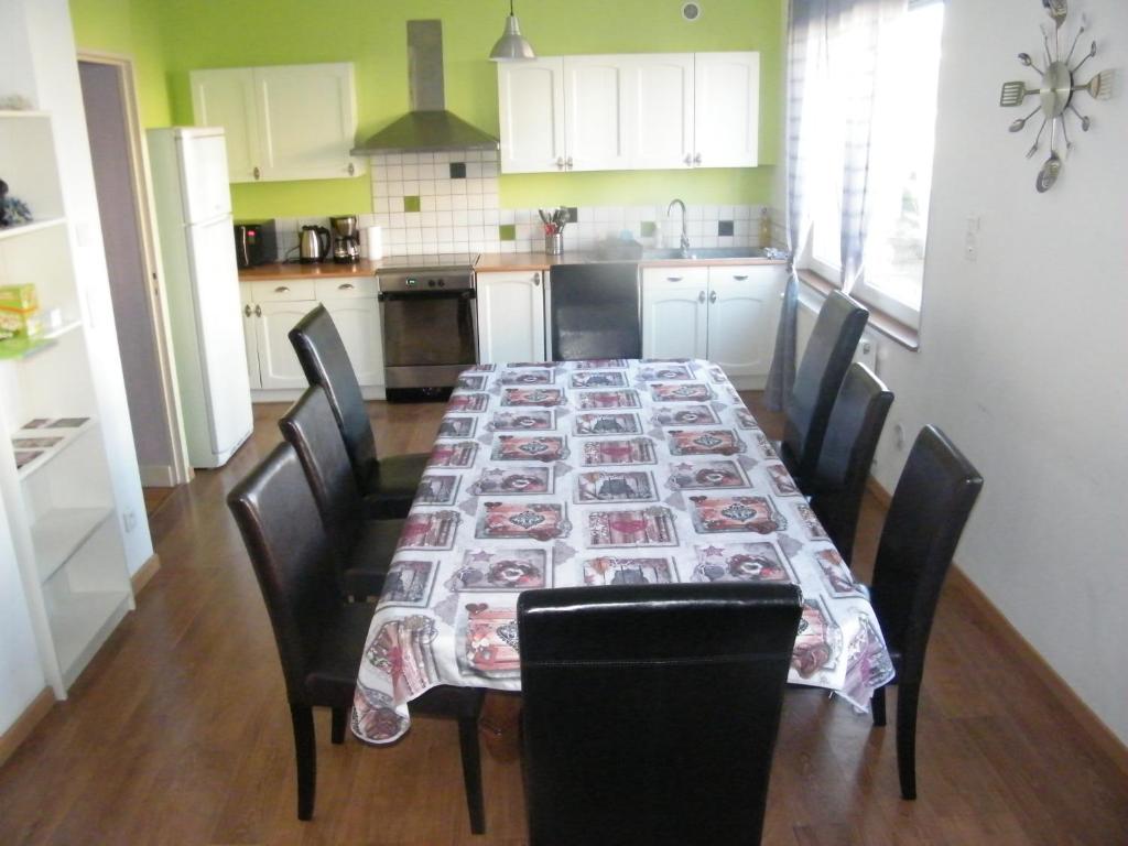 a kitchen with a dining room table with chairs at Chez Laurent et Sandrine in Chantraine