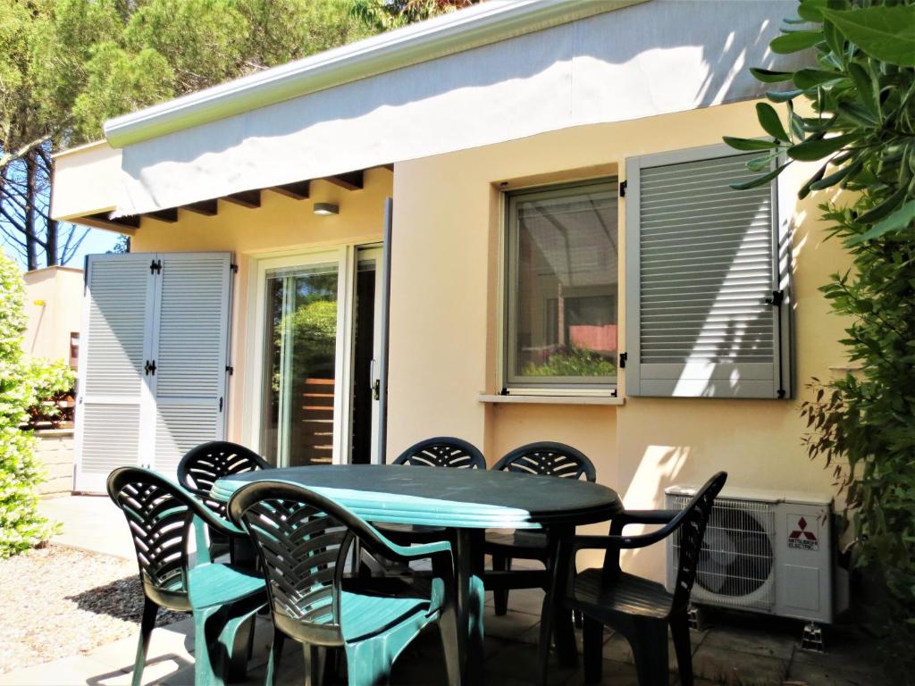 a patio with a table and chairs in front of a house at Monolocale con giardino a 100m dal mare Punta Ala in Punta Ala