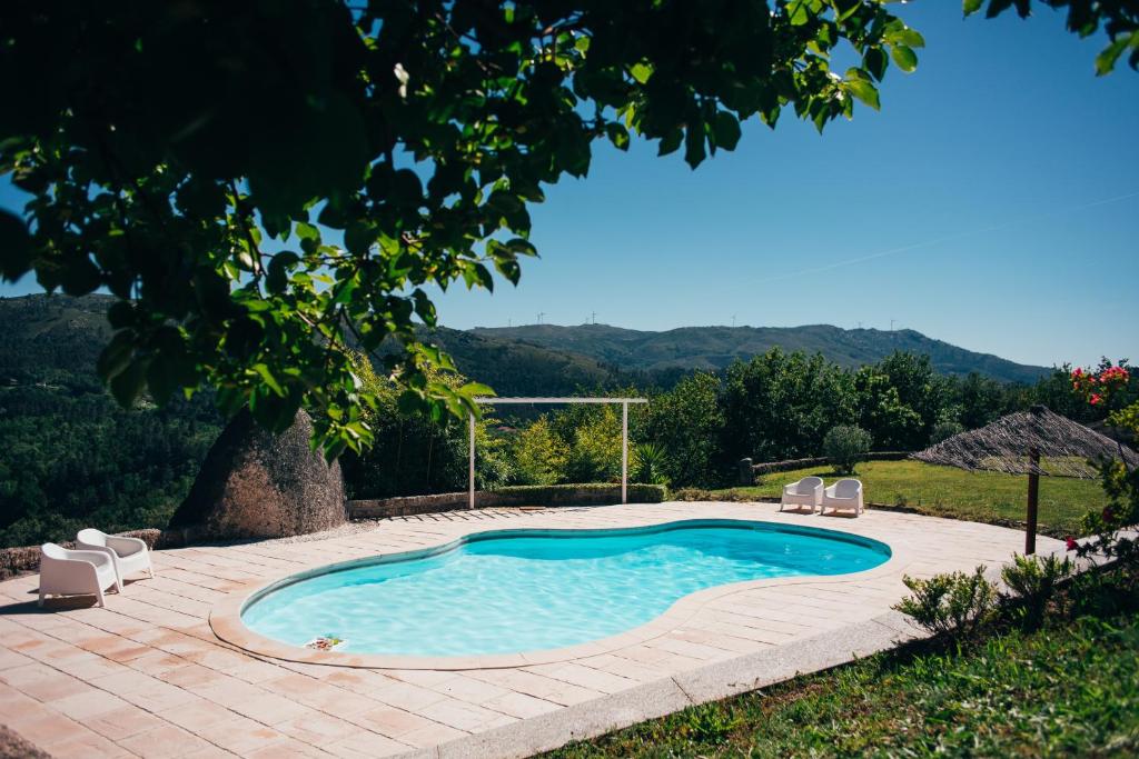 una piscina con 2 sillas de jardín junto a ella en Quinta Cercas da Costa, en Vieira do Minho