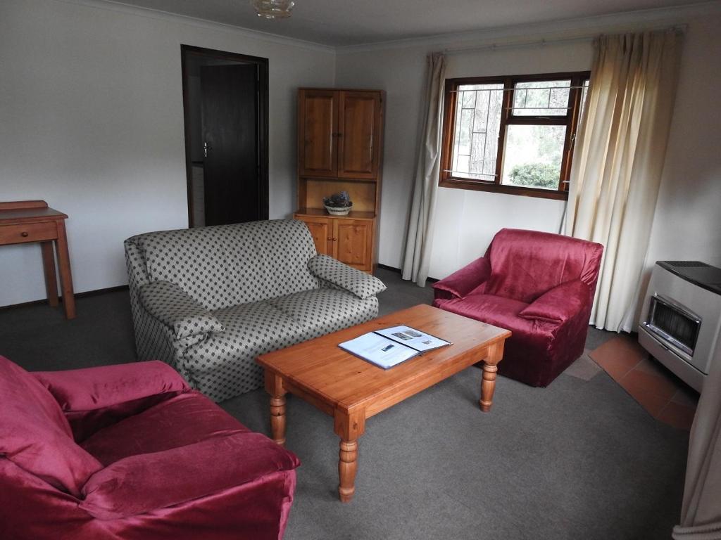 uma sala de estar com duas cadeiras e uma mesa de centro em Motebong Lodge em Bokong