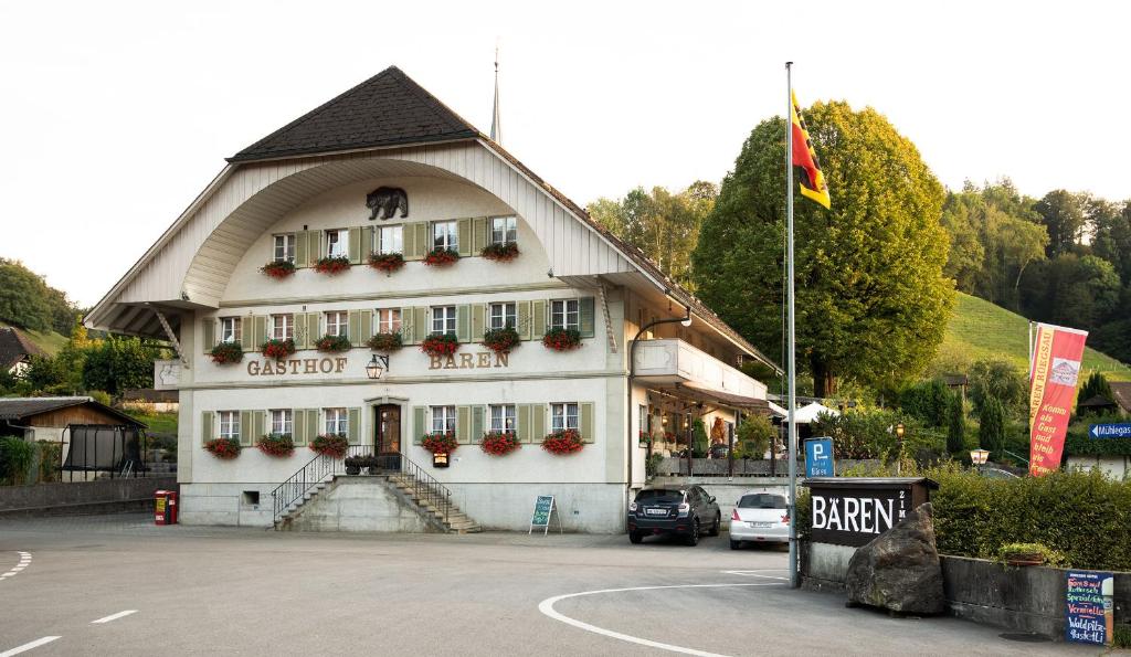 un grande edificio bianco con tetto a punta di Hotel Garni Bären Rüegsau a Ruegsau