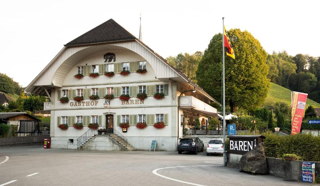 ein großes weißes Gebäude mit spitzem Dach in der Unterkunft Hotel Garni Bären Rüegsau in Ruegsau