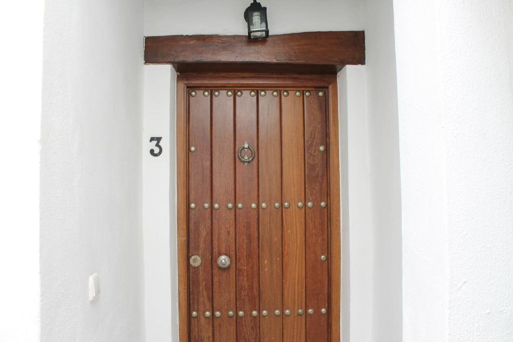 uma porta de madeira com uma luz em cima em Apartamento Rurales Rosendo: La Zajareña em Capileira