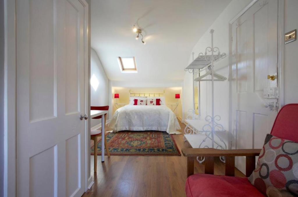 a bedroom with a white bed and a red chair at The Townhouse Central York in York