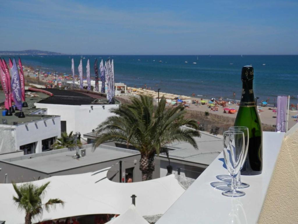 una botella de vino sentada en una mesa con una copa en studio naturiste, en Cap d'Agde