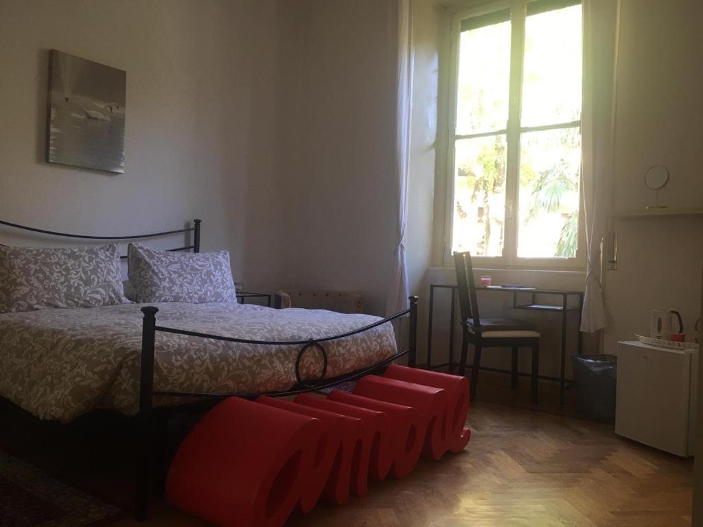 a bedroom with a bed and a chair and a window at Villa del Cigno in Lecco