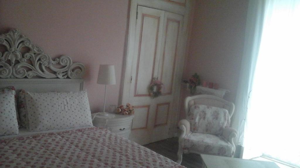 una camera con un letto bianco e una sedia di Villa Di Miscio a SantʼAgata di Puglia