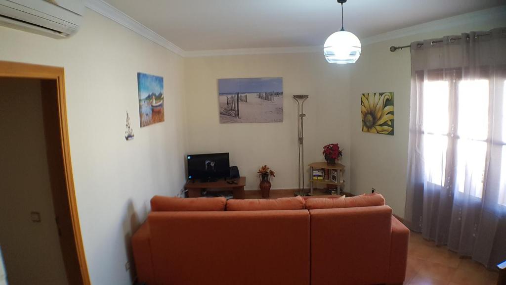 a living room with a couch and a television at Bel appartement centre de Tavira in Tavira