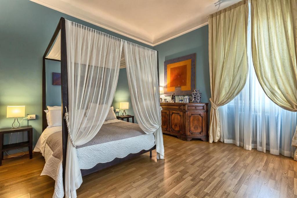 um quarto com uma cama com cortinas e um espelho em Opera Boutique B&B em Florença