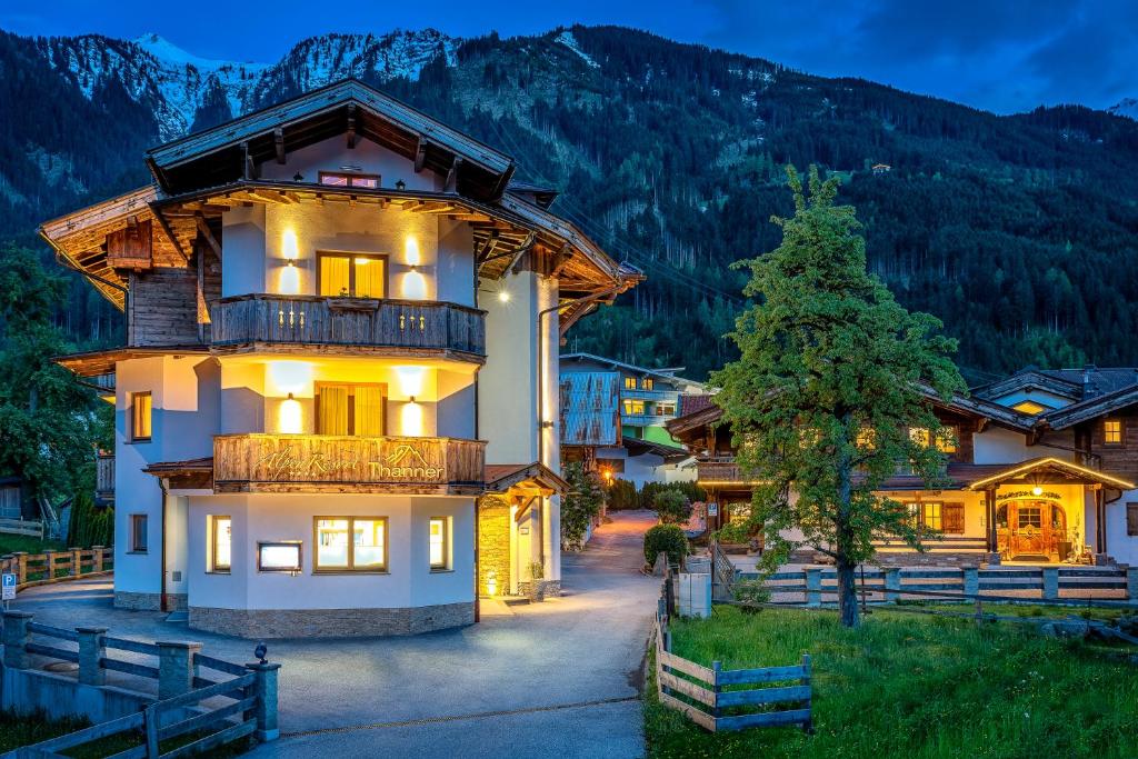 ein großes Gebäude mit einem Balkon vor einem Berg in der Unterkunft Alpenresort Thanner in Mayrhofen