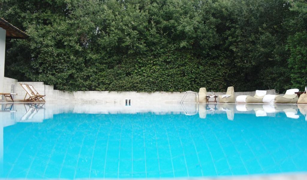 una piscina azul con un par de sillas en Villa Montignoso, en Castagno