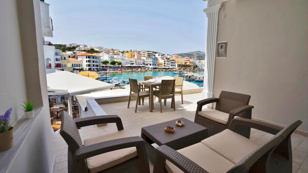a balcony with a table and chairs and a view of the water at Magic View Apartment-Karpathos Port Pigadia in Karpathos Town