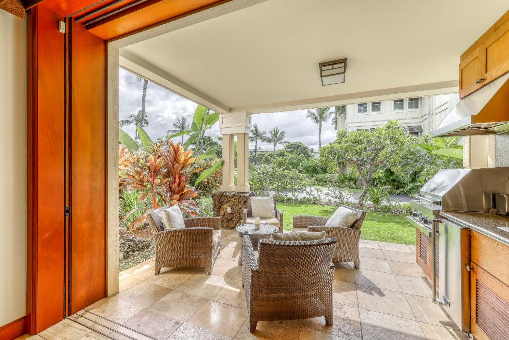 a kitchen with a patio with chairs and a table at Kolea Kai 16D in Waikoloa
