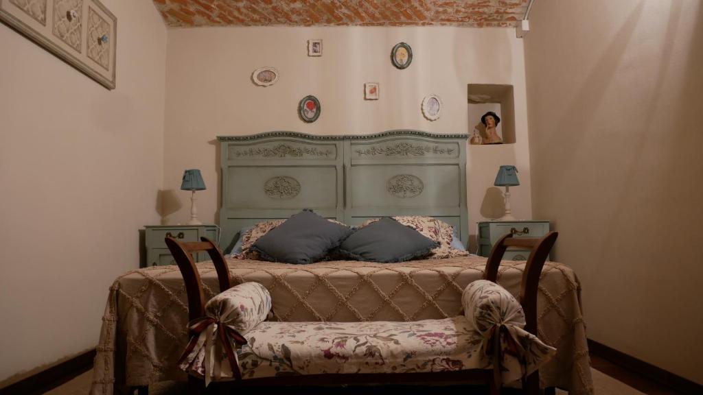 a bedroom with a large bed with two chairs at La Mianda in Ceres