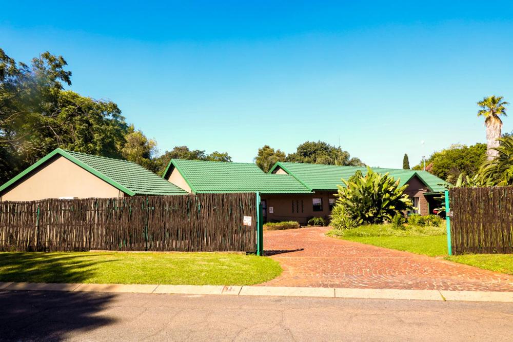 a house with a fence in front of it at The Exclusive Guesthouse in Kempton Park