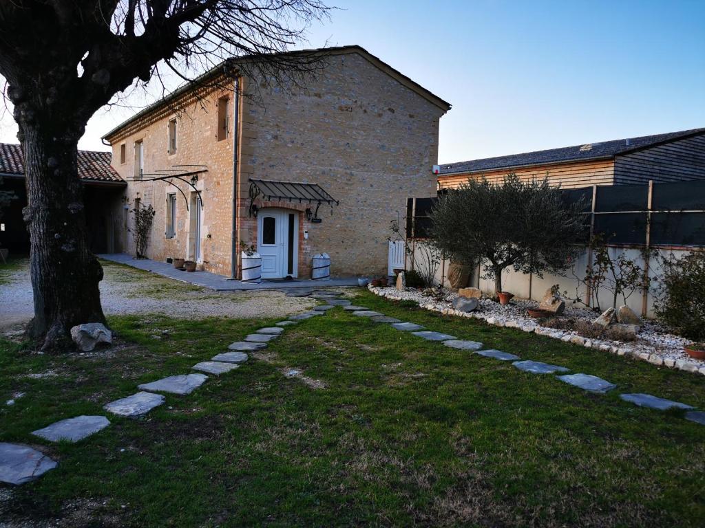 a brick building with a tree in the yard at L'AUTHENTIQUE in Eurre