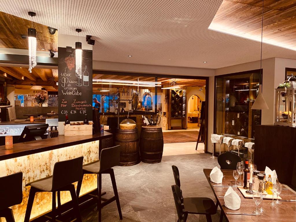 a restaurant with a bar and tables and chairs at Hotel Central in Gerlos