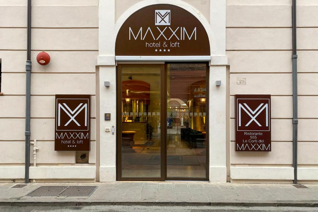 un negozio con un cartello sulla parte anteriore di un edificio di Maxxim Hotel a Ferrara