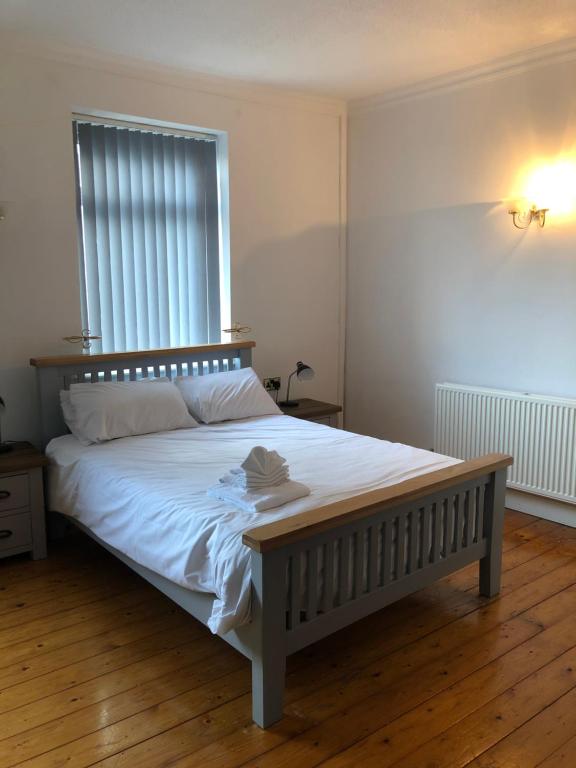 um quarto com uma cama grande e lençóis brancos em Locke House em Newport