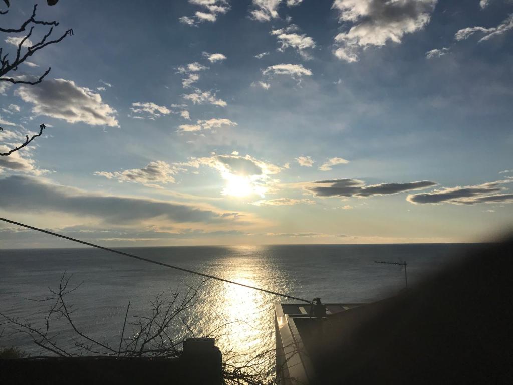 a sunset over the ocean with the sun in the sky at Casa del sasso in Bergeggi