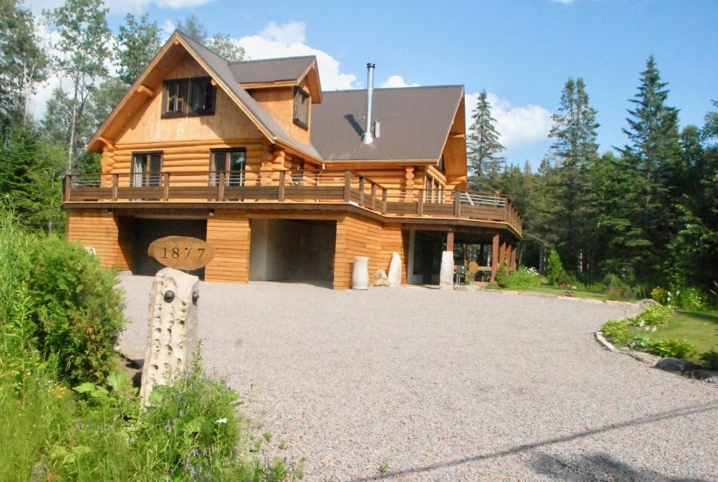una casa de madera con una gran entrada delante de ella en Le Domaine du Lac Saint Charles, en Quebec