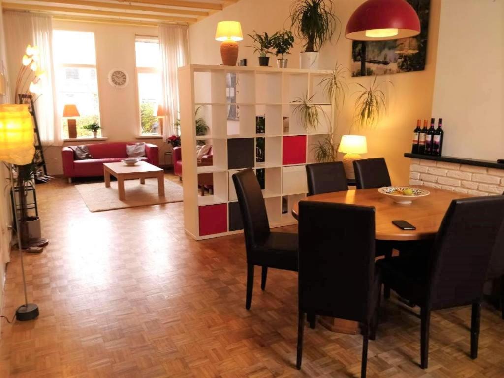 comedor con mesa y sillas y sala de estar en Domus Nimma, en Nijmegen