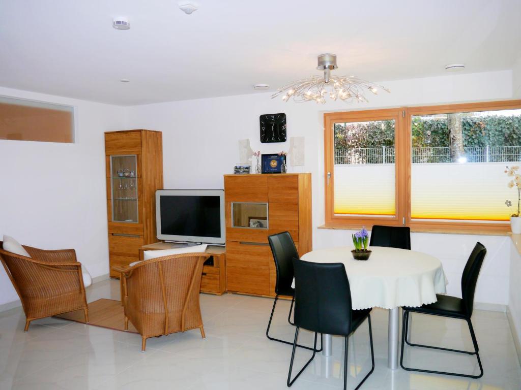 a dining room with a table and chairs and a television at Fewo Gruber in Erlangen