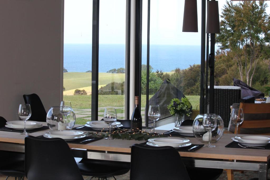 una mesa con copas de vino y vistas al océano en Te Kahu en Whangarei