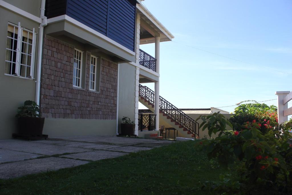 a house with a blue roof and a staircase at The AnSwin Apartment in Roseau