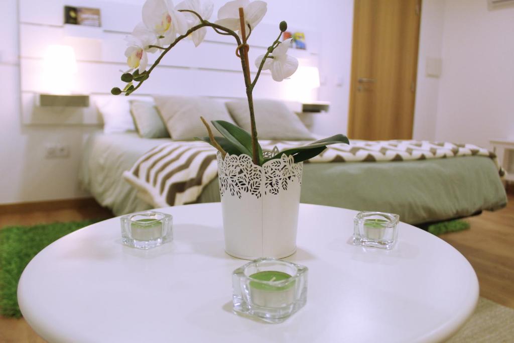 un jarrón blanco con flores sobre una mesa en la sala de estar en Sintra Cozy Suite, en Sintra