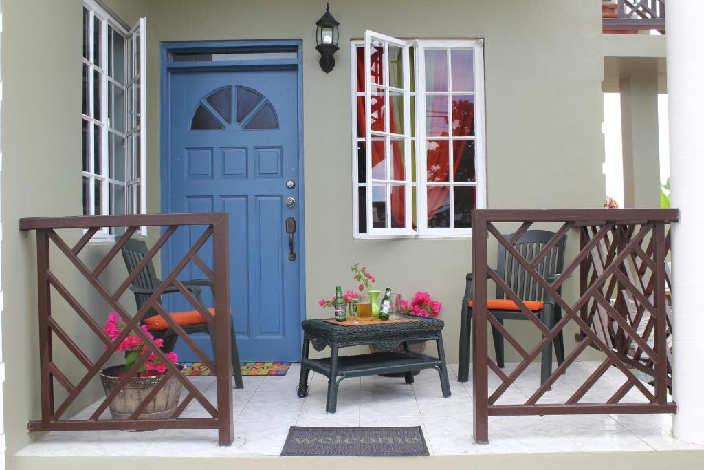 een blauwe deur op een huis met twee stoelen bij The AnSwin Apartment in Roseau