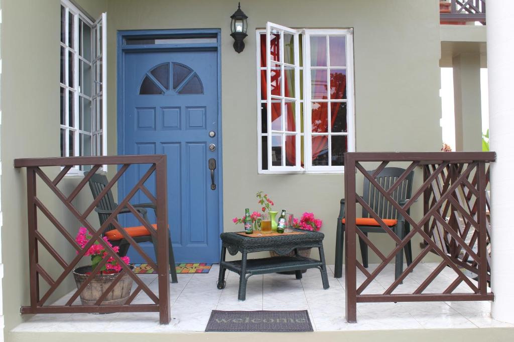 a blue door on a house with two chairs at The AnSwin Apartment in Roseau
