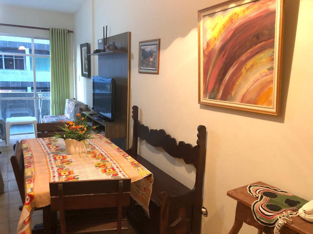 a dining room with a table and a painting on the wall at Apto Temporada Cabo Frio in Cabo Frio