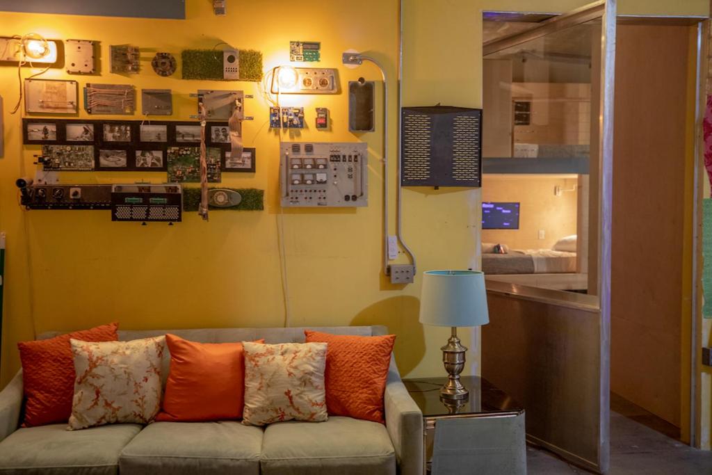 uma sala de estar com um sofá com almofadas laranja em PodShare San Diego em San Diego