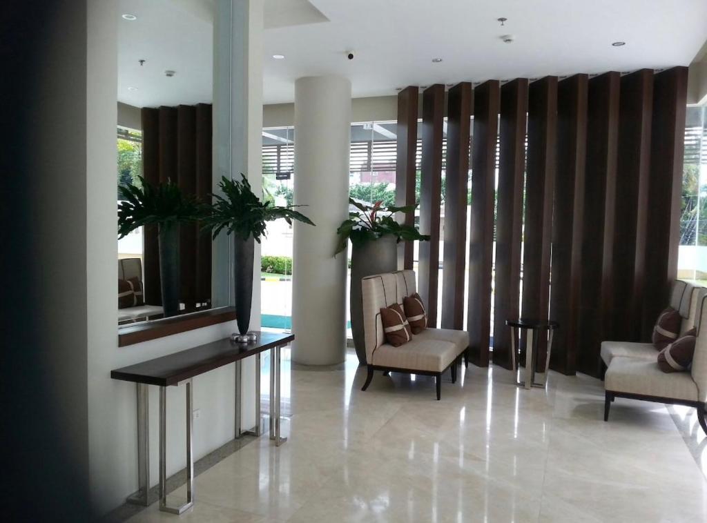 a lobby with two chairs and a table and a window at Fantastic Affordable high end condominium heart of the Cebu city in Cebu City