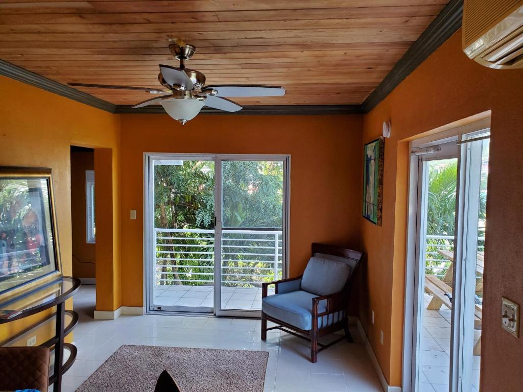 a living room with orange walls and a ceiling fan at Havensight Haven 1BR/1.5BA in Estate Thomas