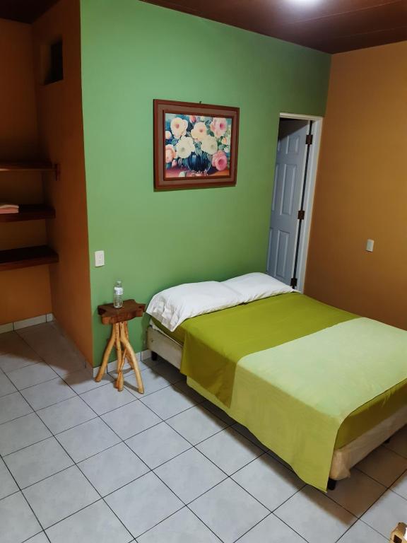 1 dormitorio con 2 camas en una pared verde en Las Casitas Hostal-Ataco, en Concepción de Ataco