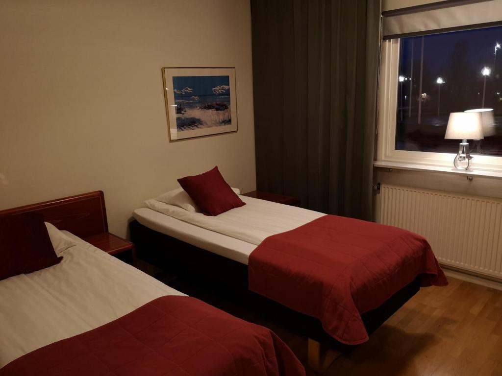 a hotel room with two beds and a window at Hotell Åsen in Anderstorp