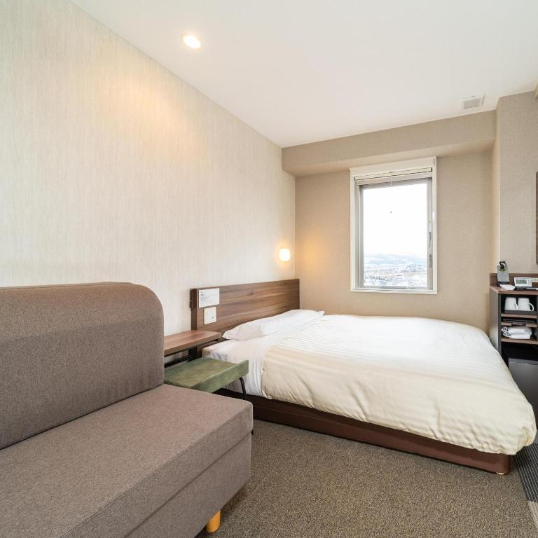 Postel nebo postele na pokoji v ubytování Super Hotel Joetsu Myoko-Eki Nishiguchi