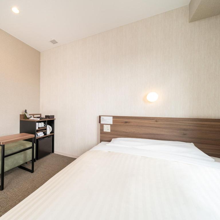 Postel nebo postele na pokoji v ubytování Super Hotel Joetsu Myoko-Eki Nishiguchi
