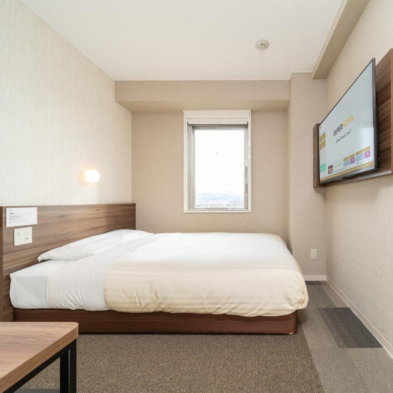 Postel nebo postele na pokoji v ubytování Super Hotel Joetsu Myoko-Eki Nishiguchi