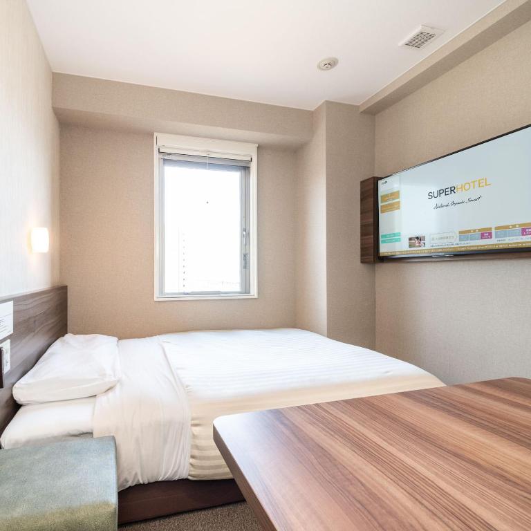 Postel nebo postele na pokoji v ubytování Super Hotel Joetsu Myoko-Eki Nishiguchi